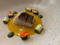 lechuga con atún marinado, microbrotes y salsa cremosa sobre base de madera