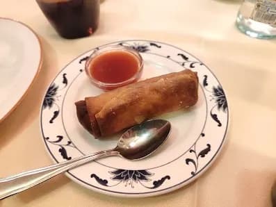 - rollito de primavera con salsa agridulce en plato de mantel blanco