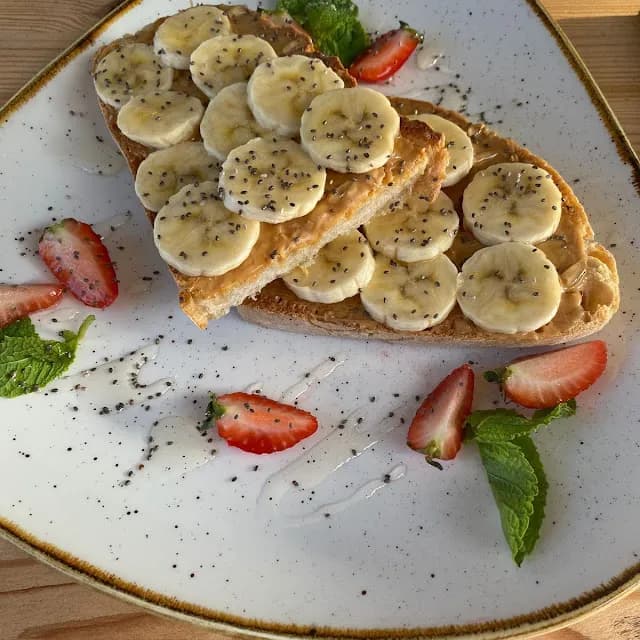 Tostada con mantequilla de cacahuete y frutas tropicales en La Maglia Coffee Co Platja dAro