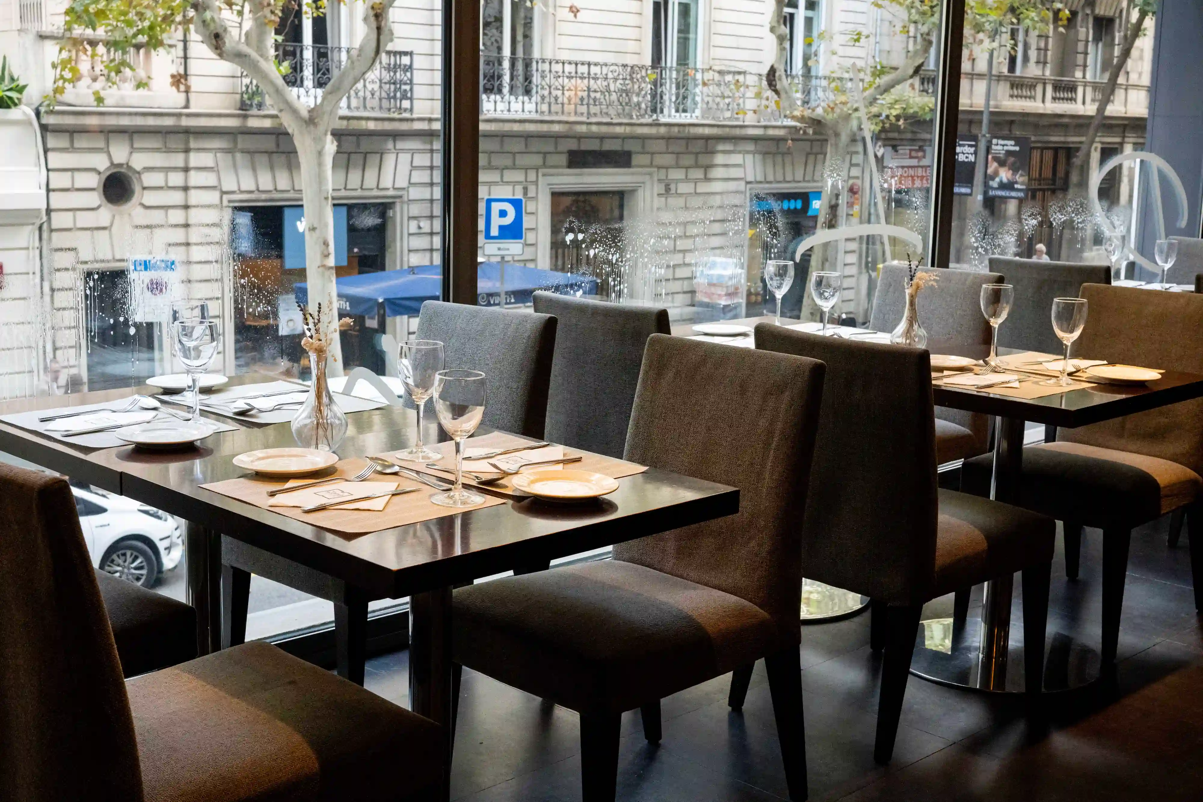 mesas modernas con vistas a la calle en restaurante zenit mediterranea barcelona